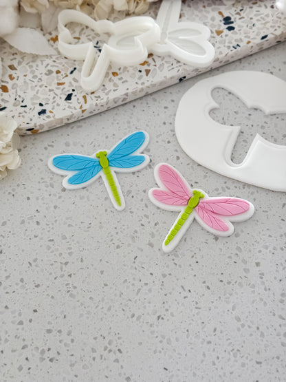 Dragonfly fondant cookies made with O'Khach dragonfly stamps and cutters, next to the cut out fondant